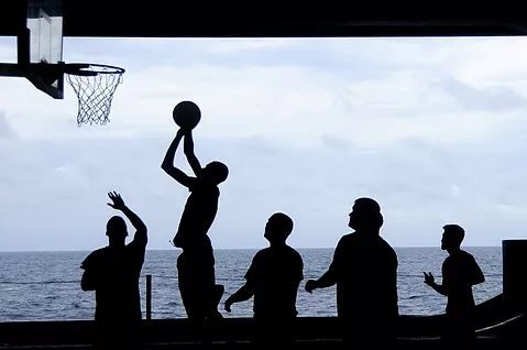 A silhouette of people playing basket ball